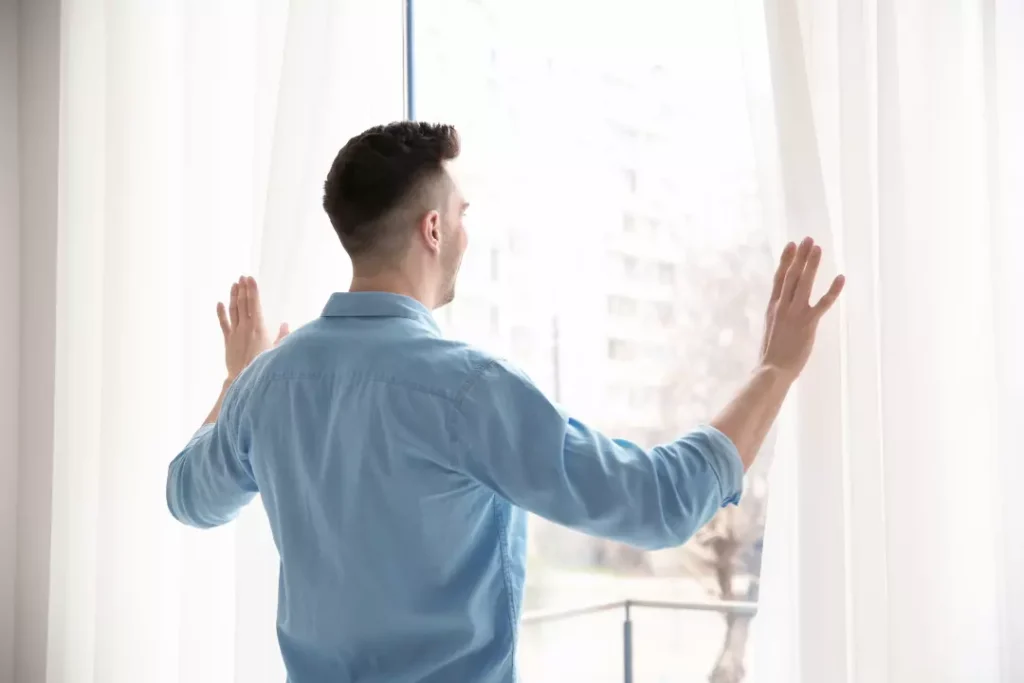 a man opening a window